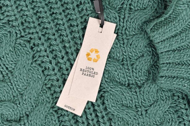 Up close image of a swing tag attached to a green sweater